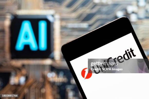 In this photo illustration, the Italian global banking and financial services company UniCredit logo seen displayed on a smartphone with an...