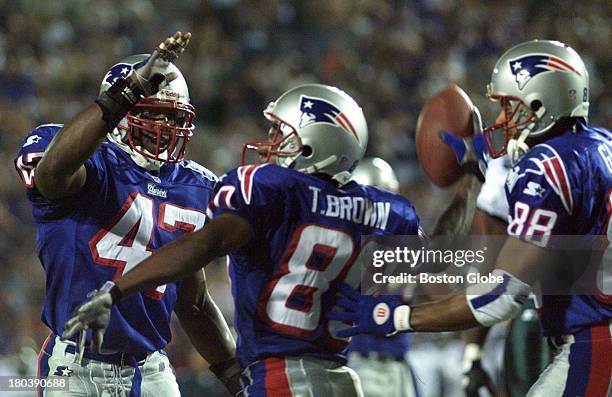 Patriots Troy Brown , with ball, celebrates his first quarter touchdown with Patriots Robert Edwards , left, and Terry Glen at right.