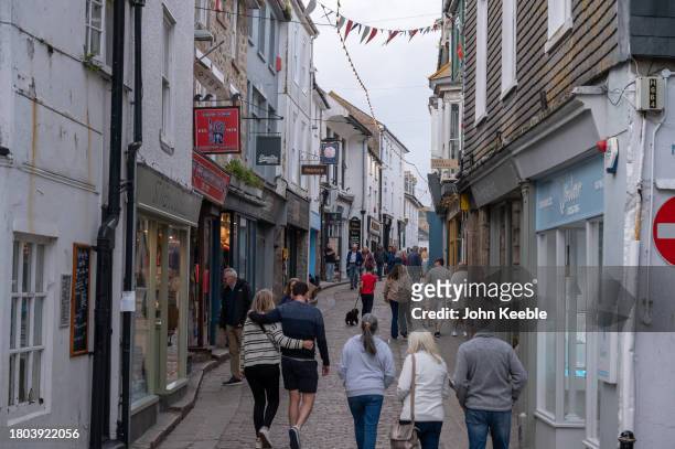 People walk along a narrow street at dusk on September 18, 2023 in St Ives, Cornwall, England.