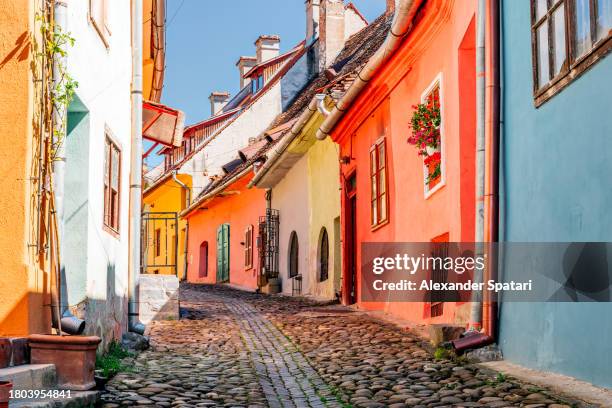 multi-colored vibrant street with colourful house in sighisoara old town, transylvania, romania - romanian house stock pictures, royalty-free photos & images