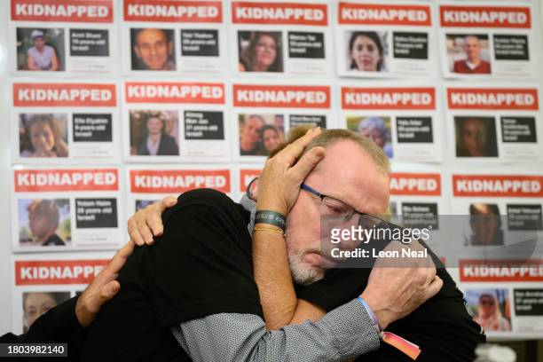 Thomas Hand , the father of Emily Hand, comforts Orit Meir , the mother of Almog Meir, as she addresses journalists during a press conference at the...