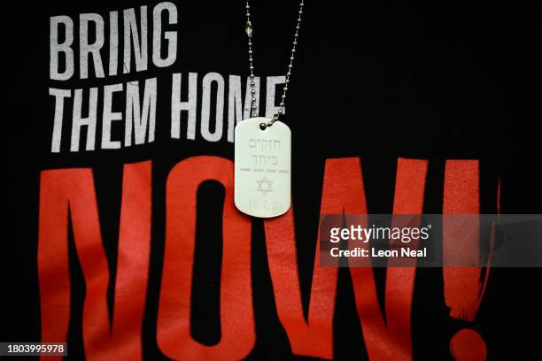An engraved dog tag bearing the date of the Hams attack on Israeli is seen as a family member of a hostage addresses journalists during a press...