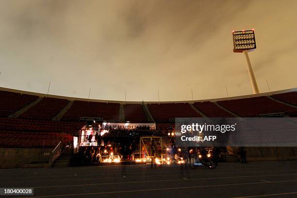 People light candles at the gates of the National Stadium, on September 11, 2013 in Santiago, Chile, during the commemoration of the 40th anniversary...