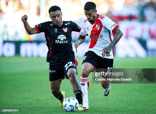 Manuel Lanzini of River Plate competes for the ball with Damian Puebla of Instituto during a match between River Plate and Instituto as part of group...