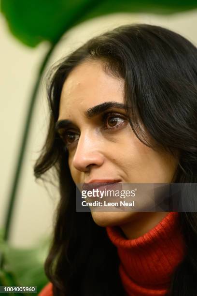 Israeli actress Liraz Charhi listens as family members of those taken hostage by Hamas speak to journalists during a press conference at the Embassy...