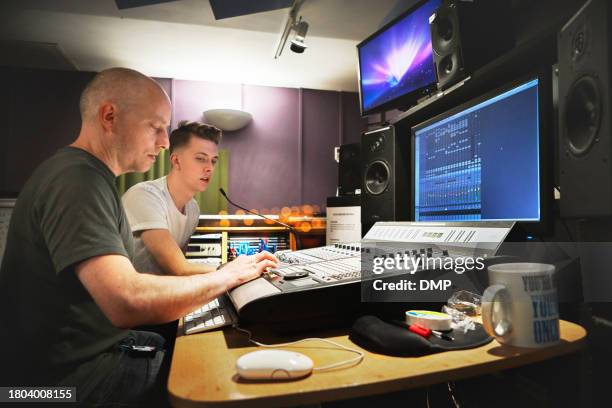 music, recording studio and a producer team working on a soundboard for art or creative engineering. technology, audio desk for production and a man technician at a record label with his assistant - singing rehearsal stock pictures, royalty-free photos & images