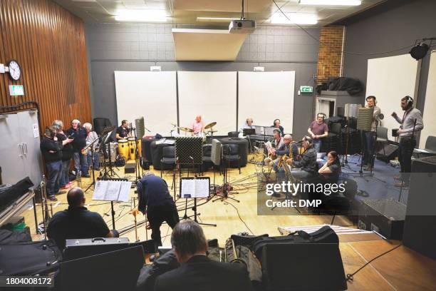 musician, people and orchestra or band for music, audio or concert in hall for entertainment. group, collaboration and instrument with headphones, notes and playing for jazz event, sound or talent - wind instrument stock pictures, royalty-free photos & images