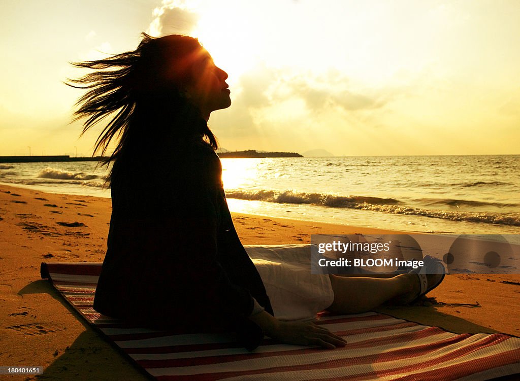 Woman Sunbathing On Beach