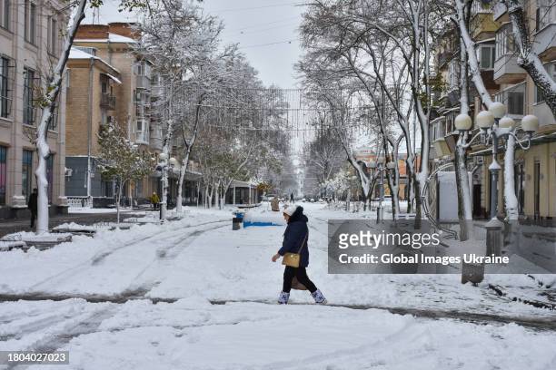 Woman crosses a snow-covered street on November 20, 2023 in Poltava, Ukraine. Since the snowfall that began on November 19 in Poltava Oblast, there...