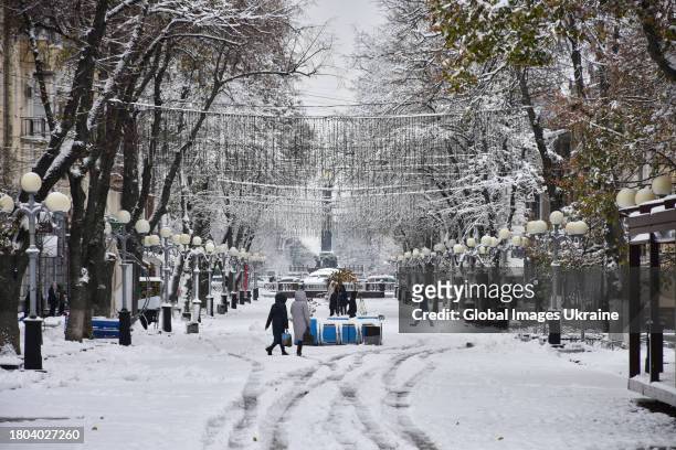 People walk down a snow-covered street on November 20, 2023 in Poltava, Ukraine. Since the snowfall that began on November 19 in Poltava Oblast,...