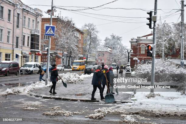 Utility workers clear snow on a road with shovels on November 20, 2023 in Poltava, Ukraine. Since the snowfall that began on November 19 in Poltava...
