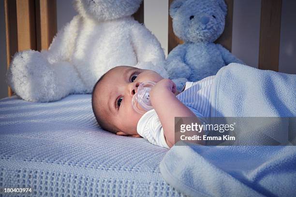 baby boy and teddy bears in crib at night - nursery night stock pictures, royalty-free photos & images