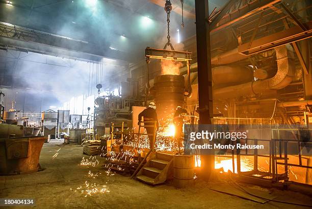 workers next to furnace pouring molten steel in industrial foundry - energy industry heat steam stock pictures, royalty-free photos & images