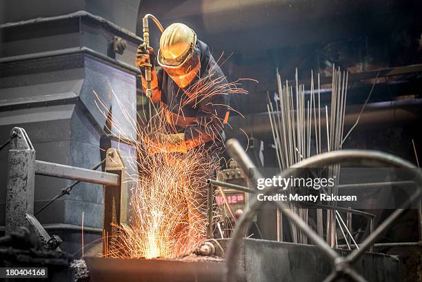 steel worker amid sparks from molten steel in industrial foundry - steel bildbanksfoton och bilder