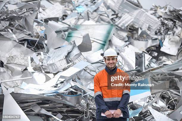 portrait of worker standing in front of scrap in aluminium recycling plant - scrap yard stock pictures, royalty-free photos & images