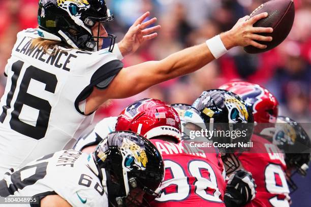 Trevor Lawrence of the Jacksonville Jaguars scores a touchdown against the Houston Texans during the first half at NRG Stadium on November 26, 2023...