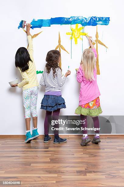 three girls painting wind turbines on wall - blonde hair rear white background stock pictures, royalty-free photos & images