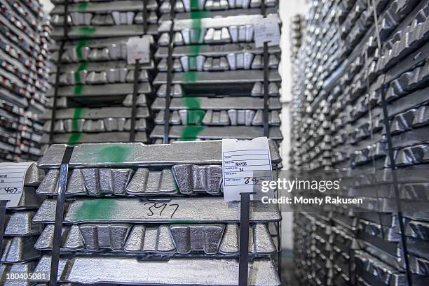 stacked alumninium ingots in warehouse awaiting delivery - aluminium ingots stockfoto's en -beelden