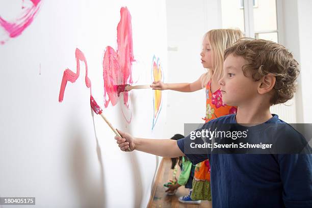 group of children painting wall - red dress child stock pictures, royalty-free photos & images