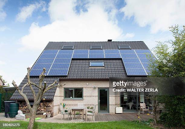 detached bungalow with solar panels on roof - einfamilienhaus mit solarzellen stock-fotos und bilder