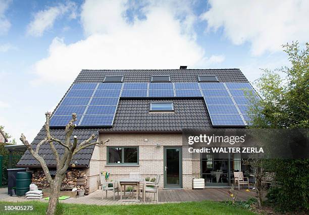 detached bungalow with solar panels on roof - zonnepanelen stockfoto's en -beelden