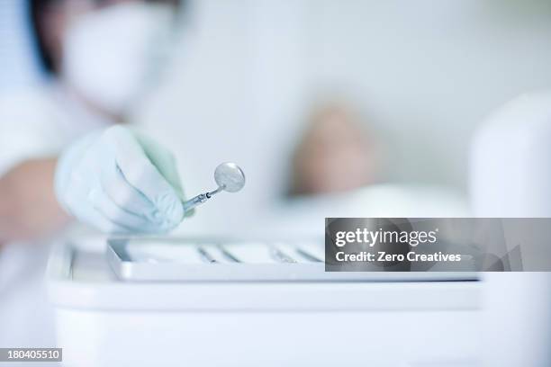 close up of hand holding dentist mirror - dental office front stock pictures, royalty-free photos & images