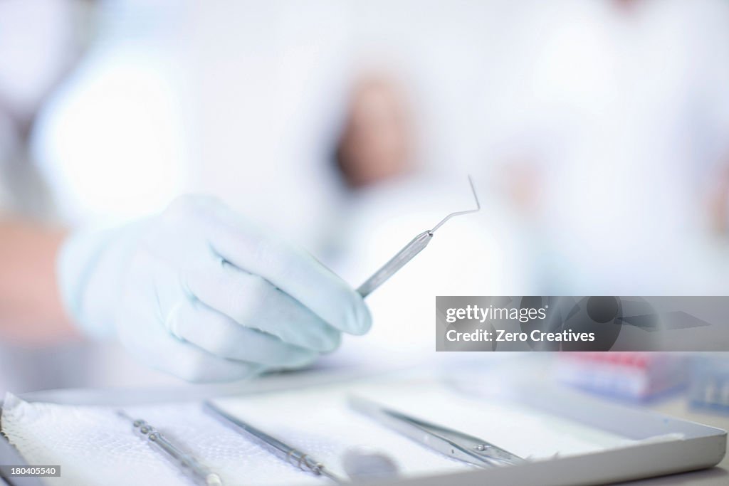 Close up of hand holding dentist instrument