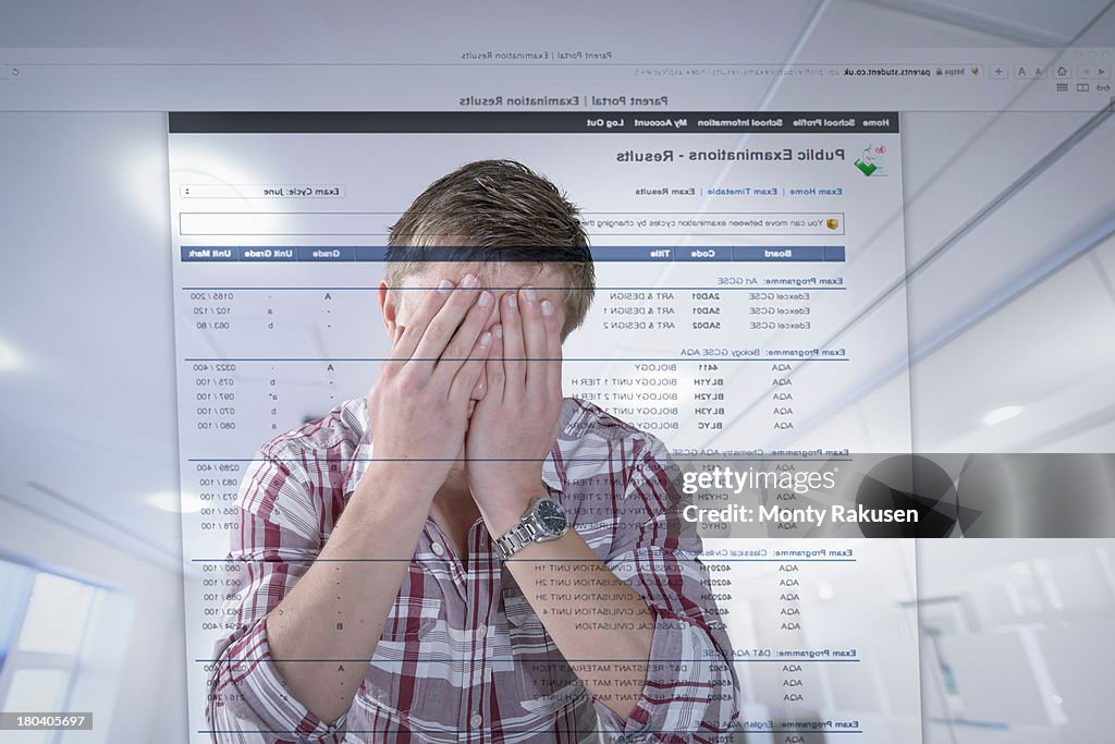 Young student reacting to examination results displayed on screen