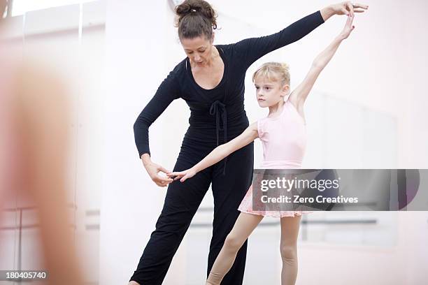 young ballerina practicing pose with teacher - dancers exercising teacher stockfoto's en -beelden