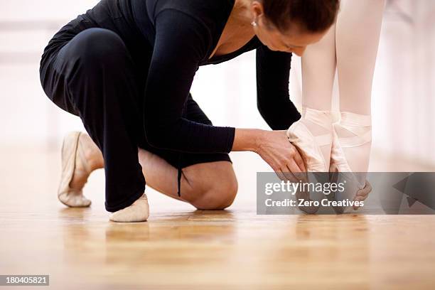 teacher adjusting foot position of ballerina - dancers exercising teacher stockfoto's en -beelden