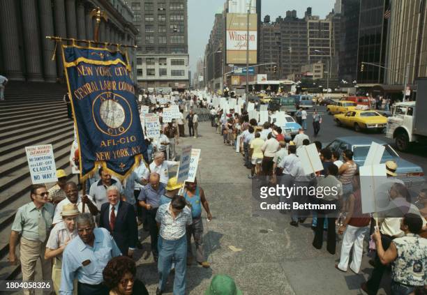Postal workers carrying placards and a union banner demonstrate outside the main post office in New York, July 19th 1978.