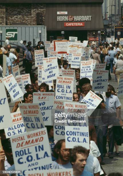 Postal workers carrying placards demonstrate outside the main post office in New York, July 19th 1978. The placards read 'Postal Workers Demand No...