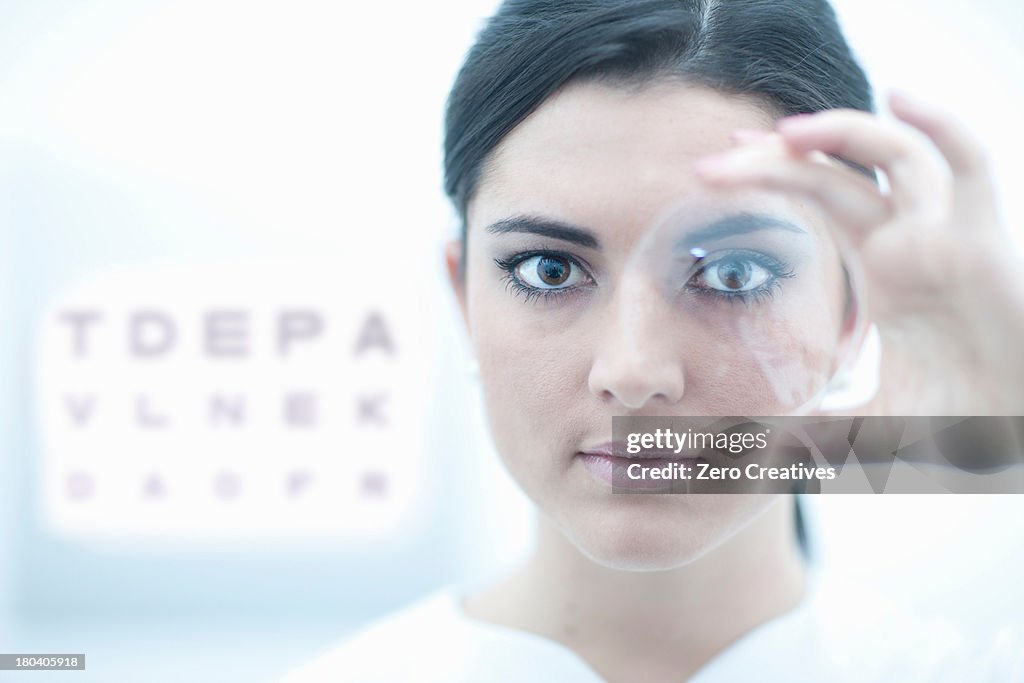 Close up of optician holding lens in eye clinic