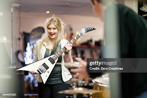 young couple in music store - guitar shop stock pictures, royalty-free photos & images