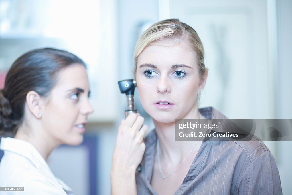 Patient having ear examined by doctor