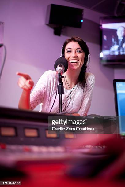 mid adult woman broadcasting in recording studio - radio dj stockfoto's en -beelden