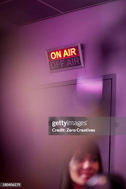 mid adult woman in recording studio with illuminated sign - radio dj stock pictures, royalty-free photos & images