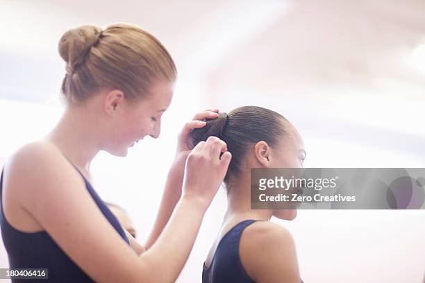 teenage ballerina helping friend with hair - pin up girl stockfoto's en -beelden