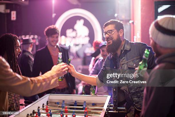 group of friends and table football game in bar - hair color saloon stockfoto's en -beelden