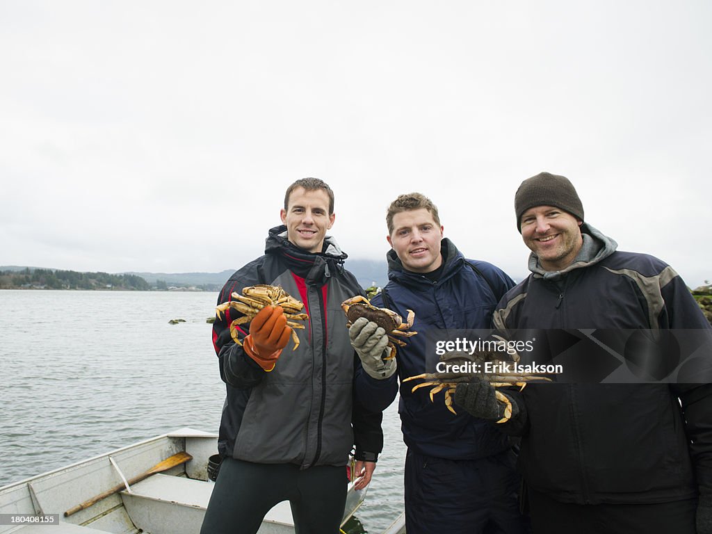 USA, Oregon, Rockaway Beach, Portrait of people holding crabs