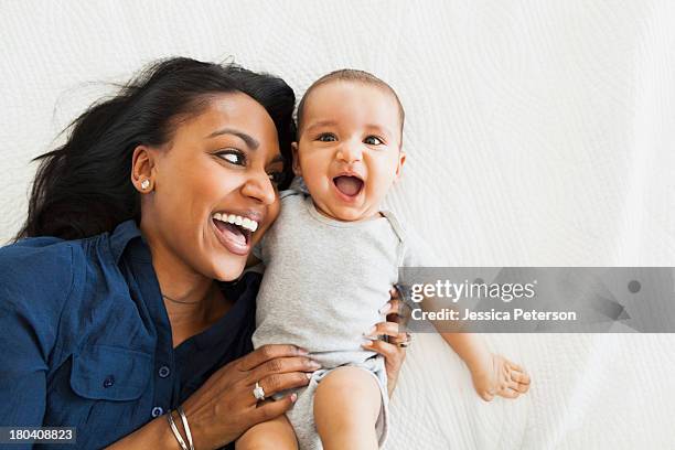 mother with baby boy (2-5 months) hugging and laughing - baby white background foto e immagini stock