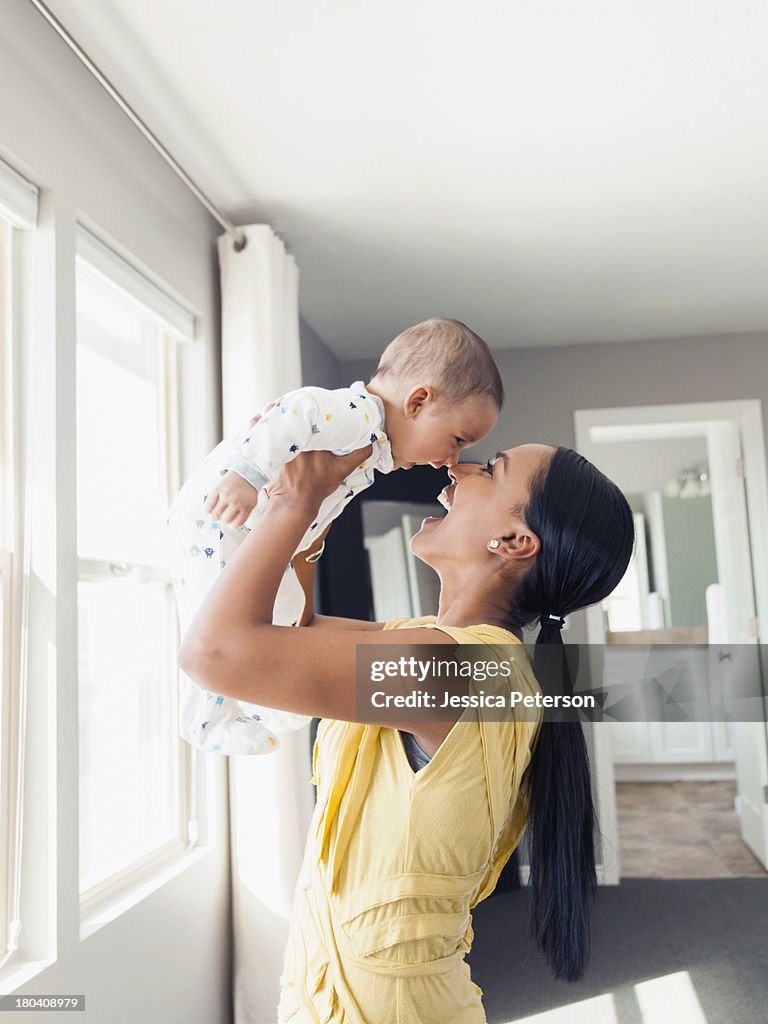 USA, Utah, Lehi, Woman holding up her baby son (3 months)