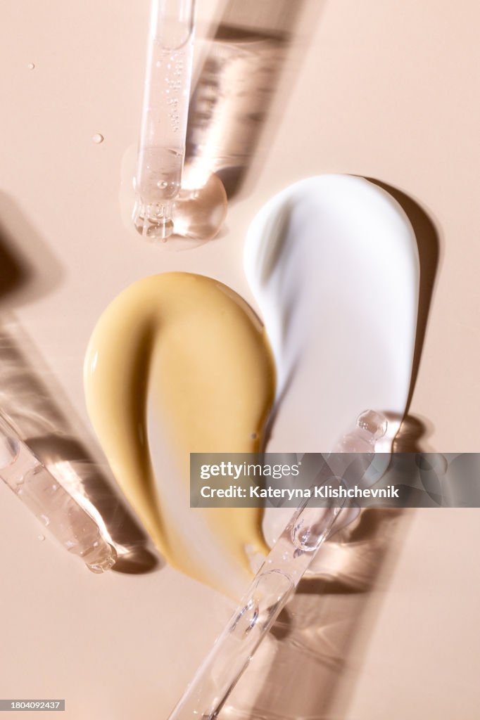 Samples of cosmetic products smears cream masks glass pipettes with serum cosmetics for face care on a beige background