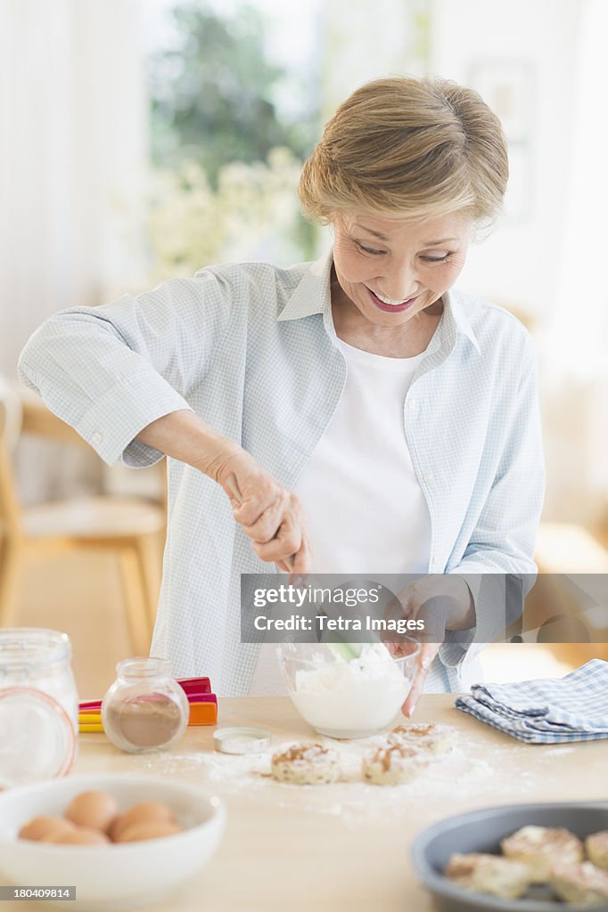 USA, New Jersey, Jersey City, Senior woman cooking in kitchen