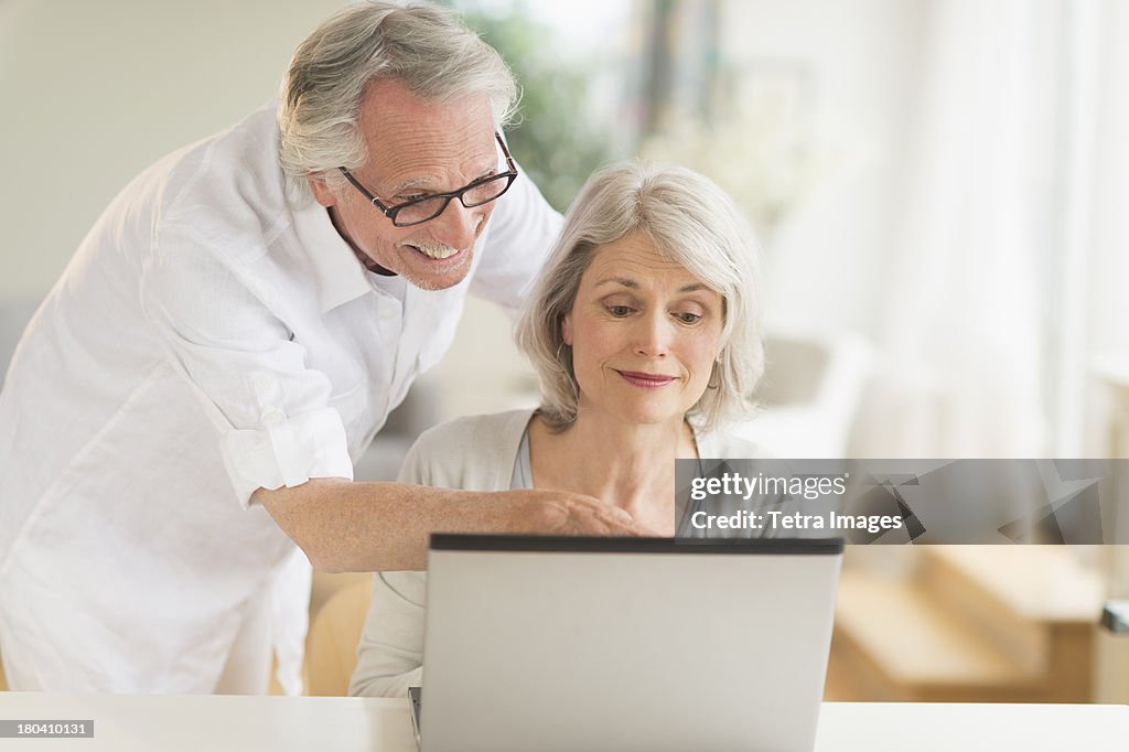 USA, New Jersey, Jersey City, Senior couple using laptop