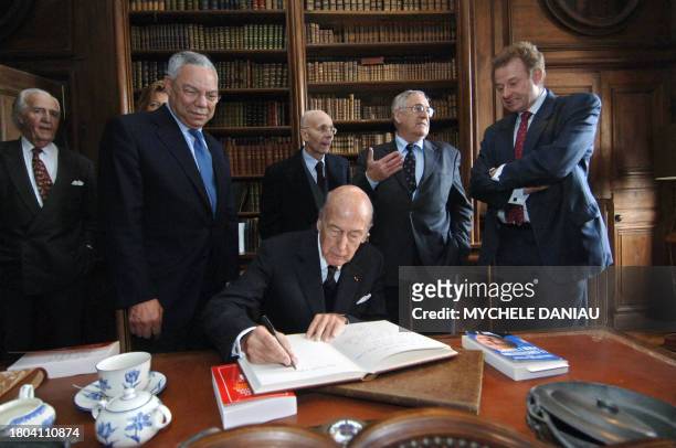 Former French President Valery Giscard d'Estaing signs a gold book after Former US Secretary of State Colin Powell has been awarded by the Alexis de...