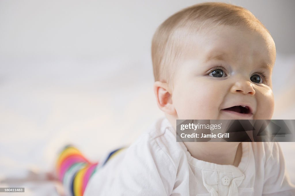 USA, New Jersey, Jersey City, Portrait of baby girl (6-11 months) lying on bed