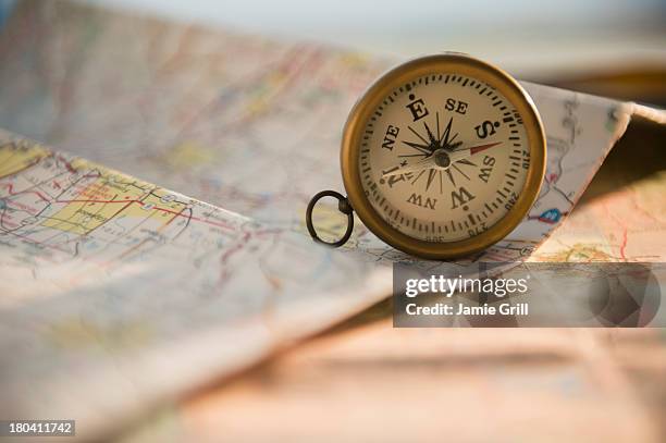 studio shot of maps and compass - kompass stock-fotos und bilder