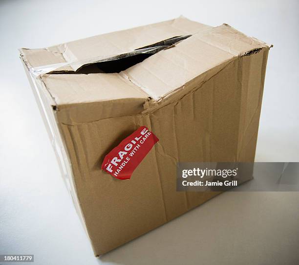 studio shot of damaged box with fragile label - damaged box stock pictures, royalty-free photos & images