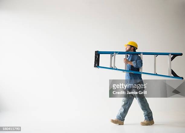 usa, new jersey, jersey city, side view of man carrying ladder - ladder imagens e fotografias de stock